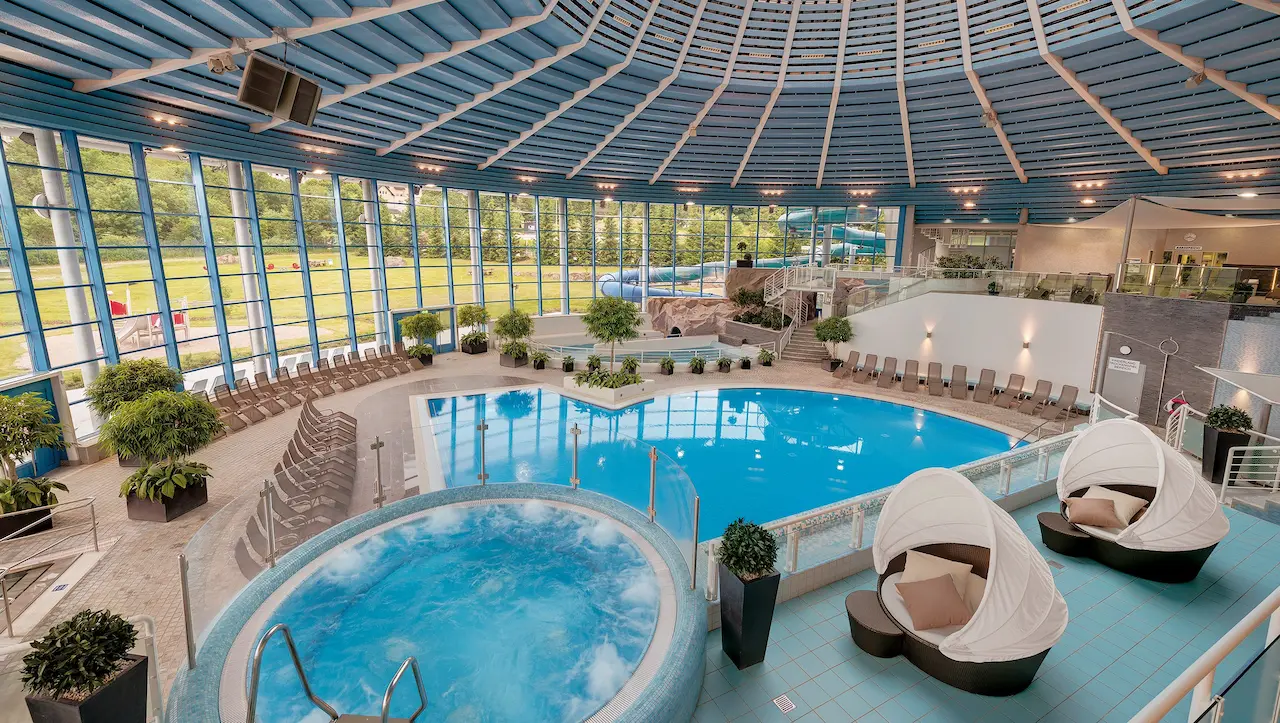 Innenansicht des H2Oberhof Bads in Oberhof mit Schwimmbecken, Whirlpool und modernen Relaxliegen.