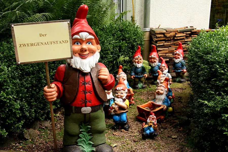 Gartenzwerge im Zwergen-Park Trusetal, angeführt von einer Figur mit Schild „Der Zwergenaufstand“.