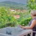 Frau sitzt auf Terrasse mit Blick auf grüne Landschaft bei Ferienwohnung Floh-Seligenthal, Thüringer Wald