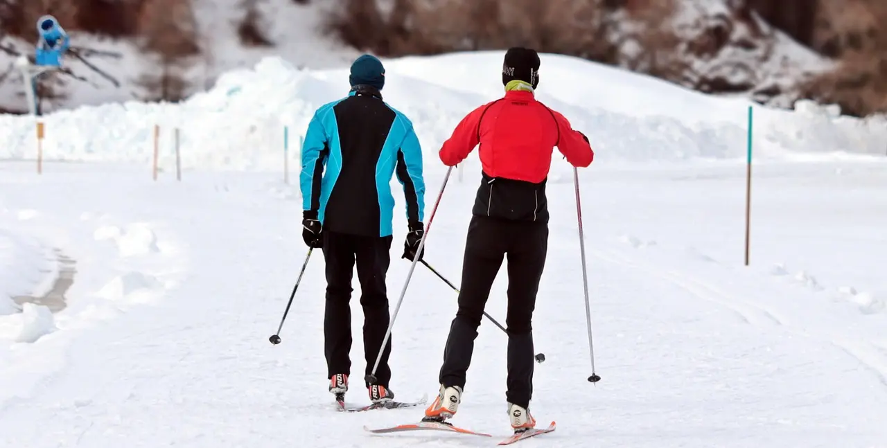 Zwei Skifahrer auf der Loipe beim Skilanglauf im Winter.