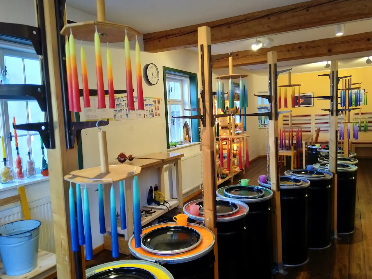 Kerzenvilla Floh-Seligenthal – Kerzenziehen in der Werkstatt (Foto: Kerzenvilla) Bunte Kerzen in der Kerzenvilla Floh-Seligenthal beim traditionellen Kerzenziehen in der Werkstatt mit Tauchwannen und Trockengestellen.